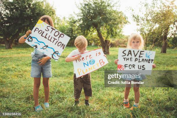 kids with posters protecting the planet. protest - laboratory for the symptoms of global warming stockfoto's en -beelden