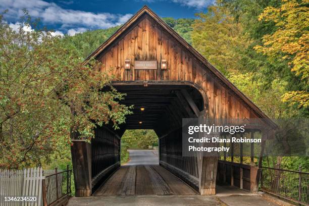 the middle bridge wooden covered bridge across the ottauquechee river in woodstock, vermont - autumn covered bridge stock pictures, royalty-free photos & images