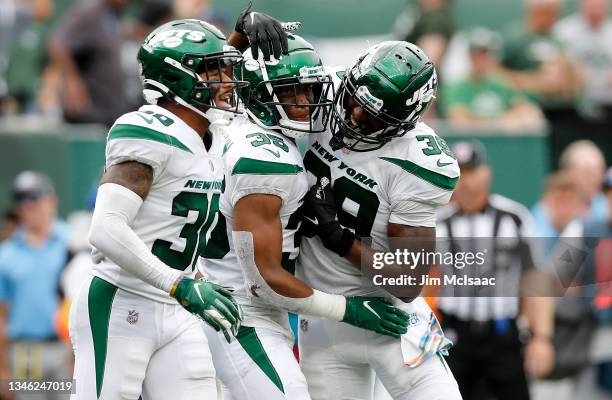 Michael Carter II, Sharrod Neasman and Jarrod Wilson of the New York Jets react after a defensive stop against the Tennessee Titans at MetLife...