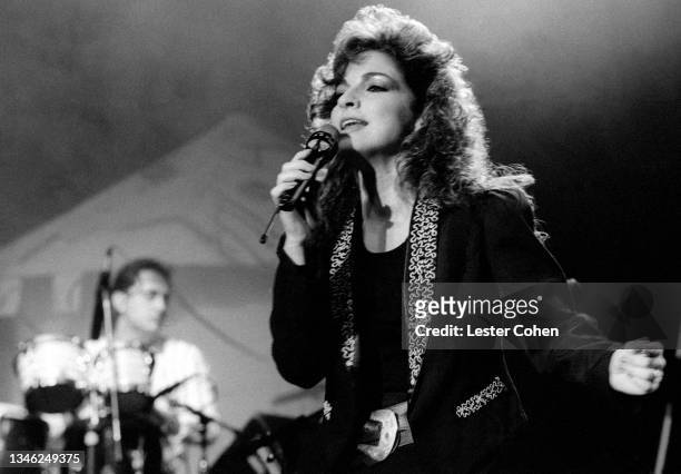 Cuban singer, songwriter, actress, and businesswoman Gloria Estefan, of the American band Gloria Estefan and the Miami Sound Machine, sings on stage...