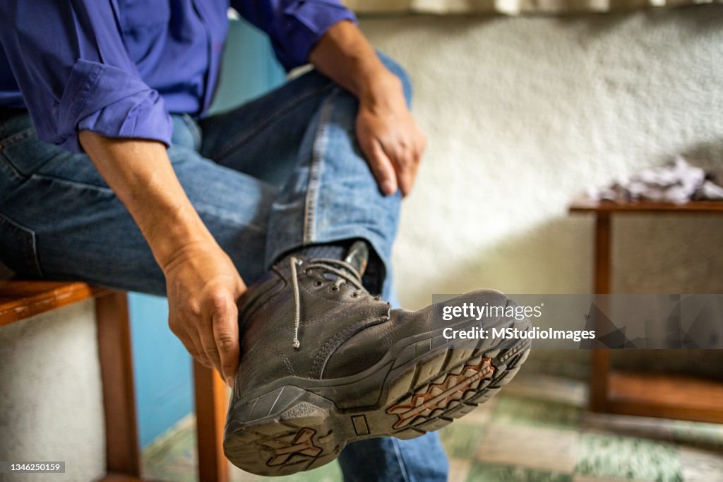 Mann zieht Stiefel an