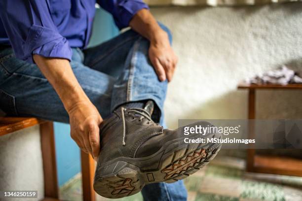 man puts on boots - senior getting dressed stock pictures, royalty-free photos & images
