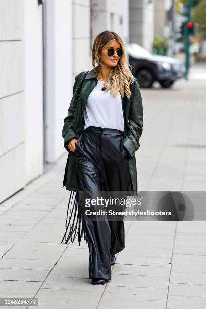 Influencer Gitta Banko wearing a dark green leather jacket by Arma, black leather pants by MM6, a white shirt by Antonia Zander, a black bag with...