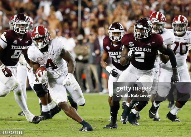 Brian Robinson Jr. #4 of the Alabama Crimson Tide rushes past Micheal Clemons of the Texas A&M Aggies at Kyle Field on October 09, 2021 in College...