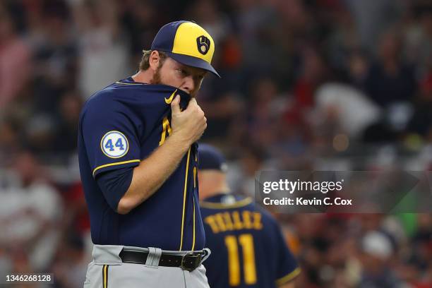 Brandon Woodruff of the Milwaukee Brewers reacts after a blooper in the infield during the seventh inning against the Atlanta Braves in game four of...