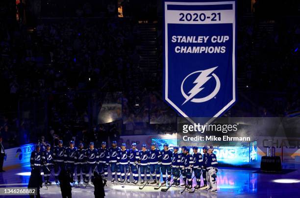 The Tampa Bay Lightning watch as a banner celebrating their 2020-21 Stanley Cup Championship before the first period of a game against the Pittsburgh...