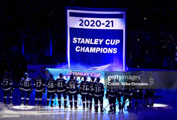 The Tampa Bay Lightning watch as a banner celebrating their 2020-21 Stanley Cup Championship before the first period of a game against the Pittsburgh...