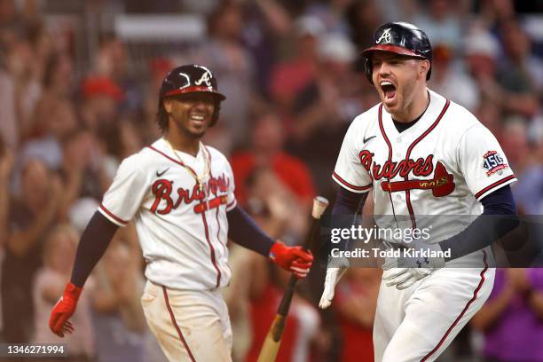 Freddie Freeman of the Atlanta Braves reacts after hitting a home run during the eighth inning against the Milwaukee Brewers in game four of the...