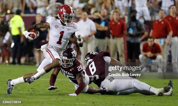 Jameson Williams of the Alabama Crimson Tide runs past Demani Richardson of the Texas A&M Aggies and DeMarvin Leal at Kyle Field on October 09, 2021...