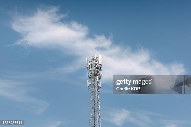 communication antenna tower of 5g network connection against blue sky background. - antennes photos et images de collection