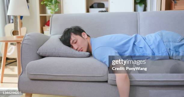 asian tired man feels exhaustion - lying on front stock pictures, royalty-free photos & images