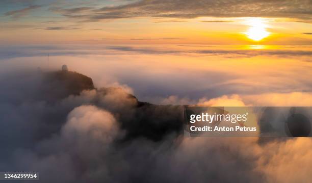 aerial view of the mountains in the clouds at sunset. faroe islands - sea ​​of ​​clouds stock pictures, royalty-free photos & images