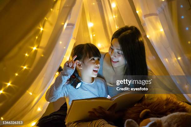 mother read fairy tale for her daughter to listen at home. - boa noite imagens e fotografias de stock