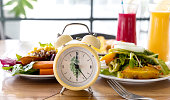 Selective focus of Food clock. Healthy food concept on wooden table background,Diet Intermittent fasting