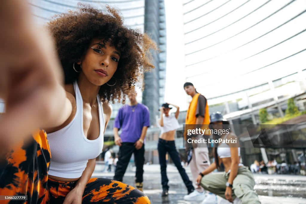 Dance group of young men and women performing in the city streets