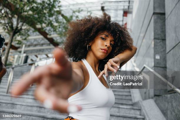 giovane donna alternativa che veste abiti urbani in posa nel centro della città - stili foto e immagini stock