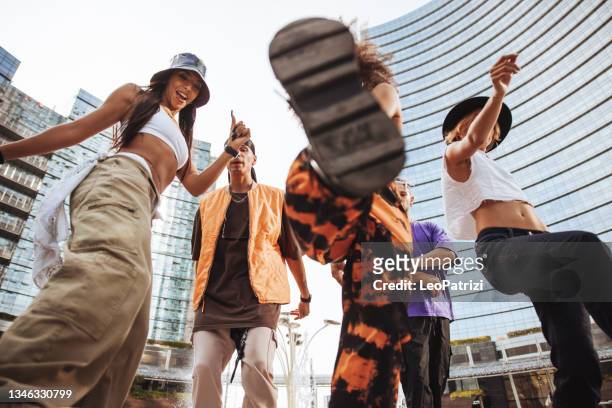 urban dancing lifestyle, group of young performers dancing with rap music in downtown - rap band stock pictures, royalty-free photos & images