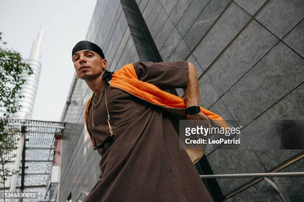 alternative man dressing urban clothes posing in city downtown - raps stock pictures, royalty-free photos & images