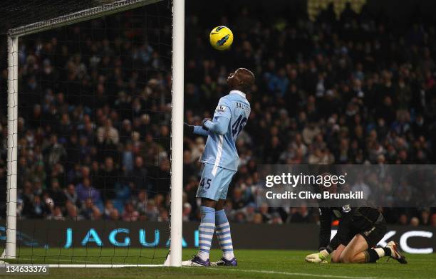 Mario Balotelli of Manchester City about to score the fourth goal as Norwich City keeper John Ruddy watches during the Barclays Premier League match...