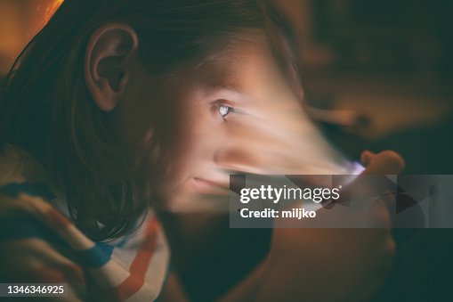 Boy playing games on mobile phone in his bed Boy playing games on mobile phone in his bed