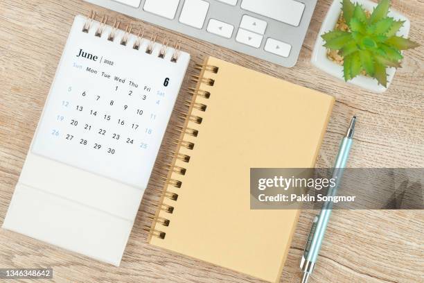 calendar desk 2022 on june month, top view calendar and pen, notebook on wooden table background. - calendar june stock pictures, royalty-free photos & images