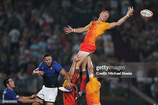 James Rodwell of England flicks the ball on at a line out during the Final match between England and France on Day Three of the IRB Dubai Sevens at...