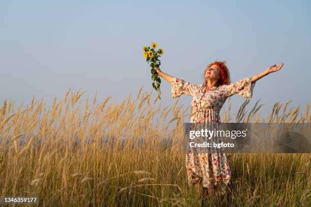 senior red haired woman breathes fresh air - fall bouquet stock pictures, royalty-free photos & images