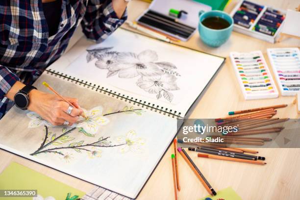 close-up of a woman's hand holding a pencil and drawing on a notebook - sketch pad stock pictures, royalty-free photos & images