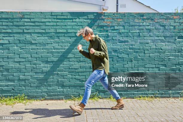 woman walking and cheering with fists. - punching the air stock pictures, royalty-free photos & images