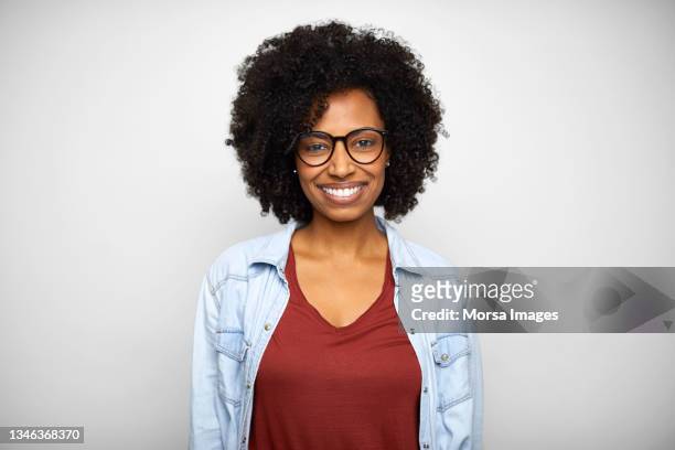 portrait of smiling african american young woman in casuals - afro woman fotografías e imágenes de stock