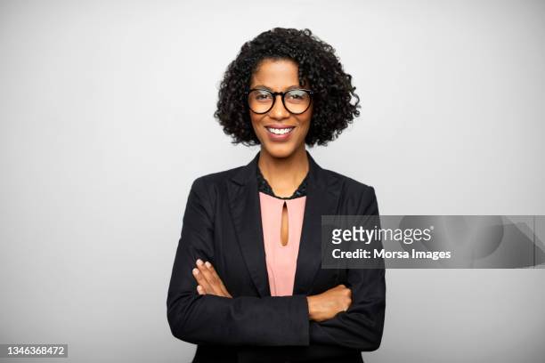 portrait of confident african american businesswoman with arms crossed - african american businesswoman photos et images de collection
