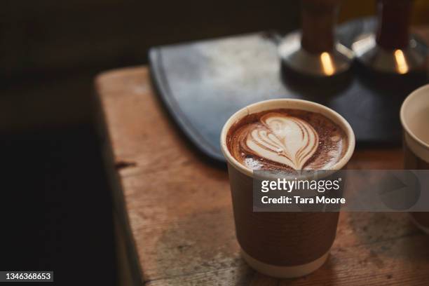 still life of hot drink in a paper cup on wooden bench. - caffè mocha stockfoto's en -beelden