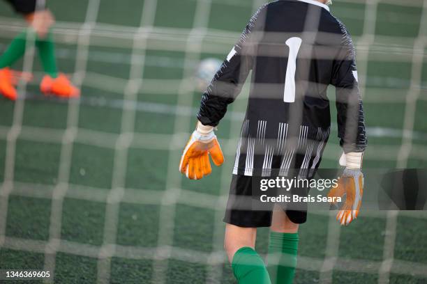 young goalkeeper ready behind the net - goalkeeper gloves stock pictures, royalty-free photos & images