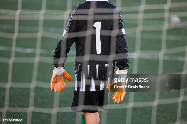 young goalkeeper ready behind the net - goalkeeper soccer stockfoto's en -beelden