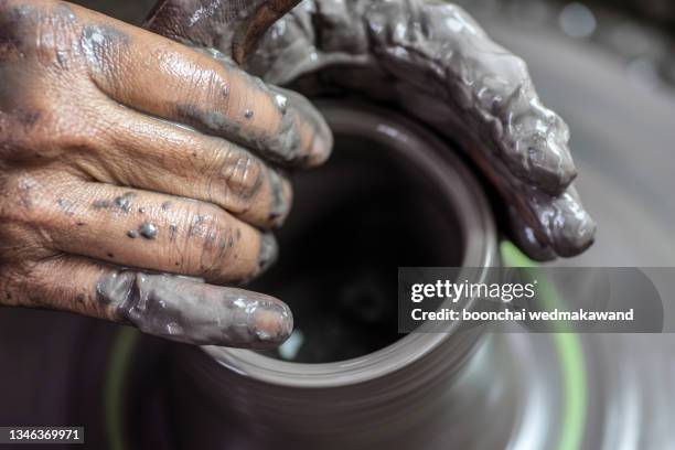 the hands of a potter, creating an earthen jar on the circle, close-ups - artists model stock-fotos und bilder