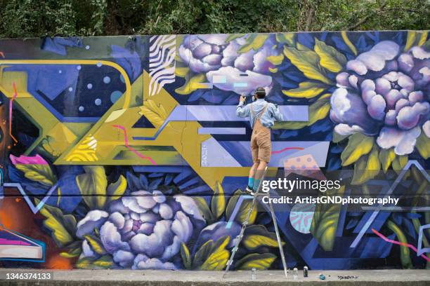 graffeur peignant sur mur. - street art photos et images de collection