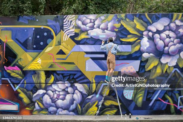 graffiti artist painting on wall. - street art graffiti foto e immagini stock