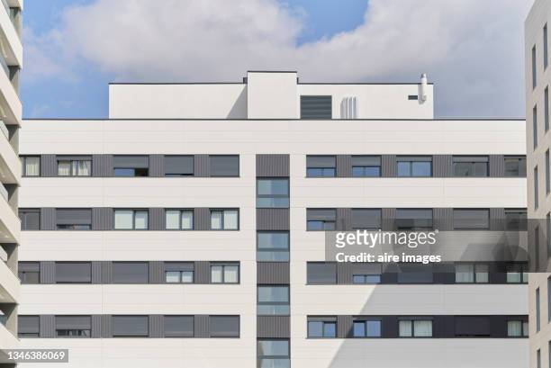 close-up of low angle view of apartment gray and white building at sunny day against blue sky - fachadas imagens e fotografias de stock