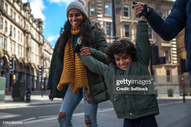 swings in the city - child winter coat stock pictures, royalty-free photos & images