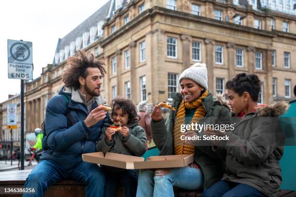 enjoying a pizza in the city - child winter coat stock pictures, royalty-free photos & images