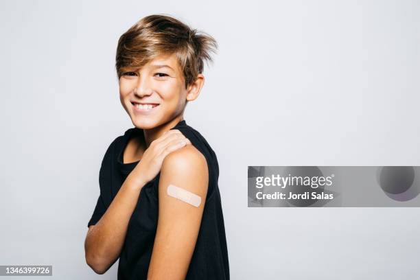 boy after getting vaccinated of covid-19 - studio shot stock-fotos und bilder