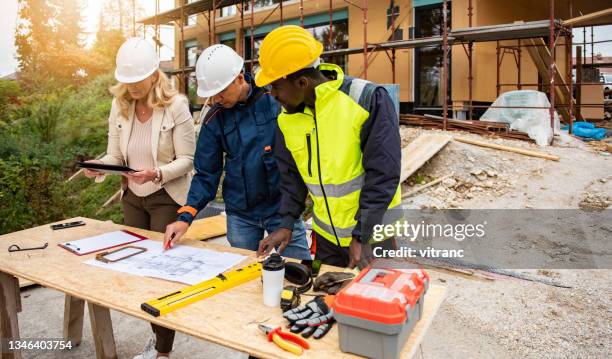 team di progetto di costruzione che lavora su un progetto in cantiere - foundations gender equality discussion foto e immagini stock