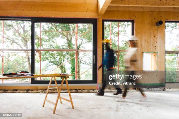 arbeiten auf der baustelle in verschwommener bewegung - bauen holz stock-fotos und bilder