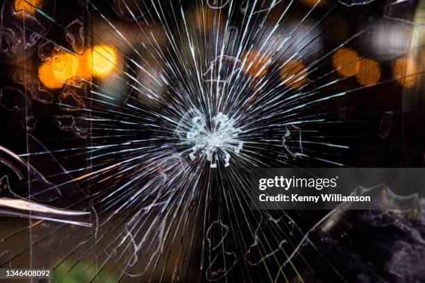 close up of a broken shop window - vandalisme stockfoto's en -beelden