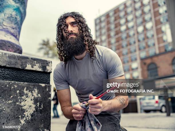 young artist working on street sculpture - male artist stock pictures, royalty-free photos & images