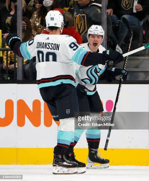 Marcus Johansson of the Seattle Kraken celebrates with teammate Ryan Donato after he scored the first goal in the team's history with his tally at...