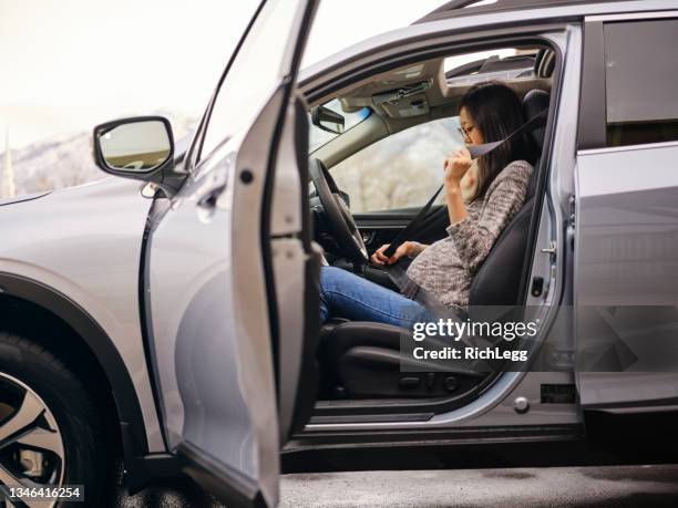 pregnant woman buckling a seatbelt in a car - pregnant woman car stock pictures, royalty-free photos & images