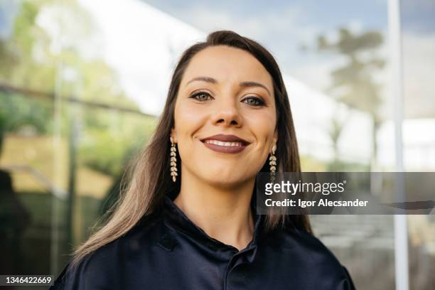 portrait of a smiling graduate woman outdoors - brinco pendente imagens e fotografias de stock