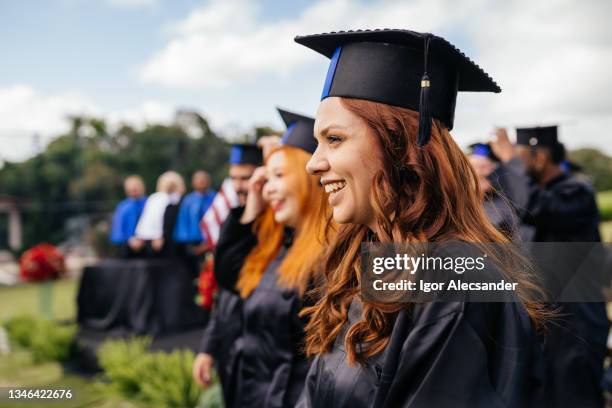 smiling graduate at graduation ceremony - graduating stock pictures, royalty-free photos & images