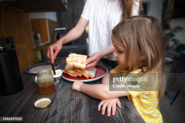 madre preparando tostadas y mermelada de desayuno - untar de mantequilla fotografías e imágenes de stock